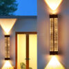 Đèn LED tường 676 lắp tường ngoài cạnh cửa gỗ lúc hoàng hôn, hai chùm sáng vàng lên xuống