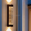 Cận cảnh đèn LED tường 676 gắn tường ngoài nhà lúc chập tối, thủy tinh bọt khí sáng vàng